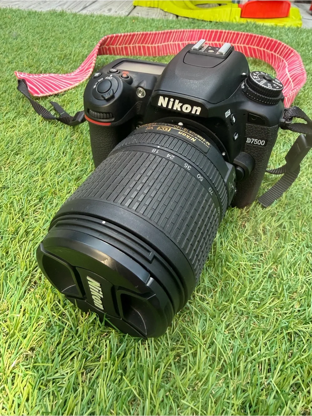 Nikon D7500 DSLR Camera with Black Lens and Red Strap